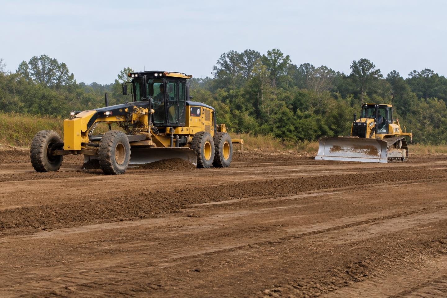 Motor grader and dozer leveling soil — sample imagery